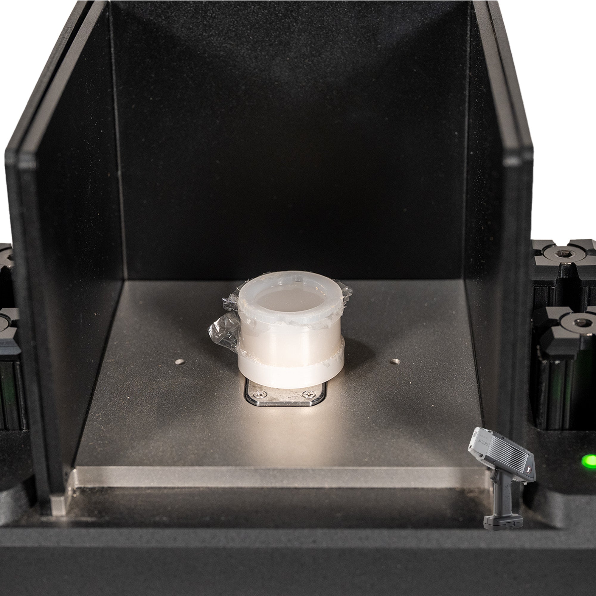 The SciAps X505 Handheld XRF Benchtop Test Stand showing the sample chamber and a sample cup
